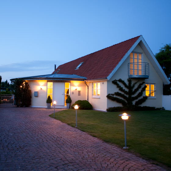 Hvid villa med tændte udendørslys