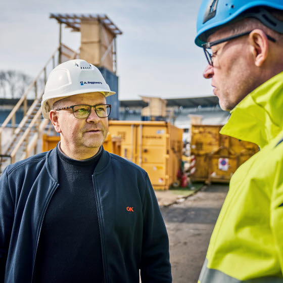 To mænd med sikkerhedshjelme på byggeplads
