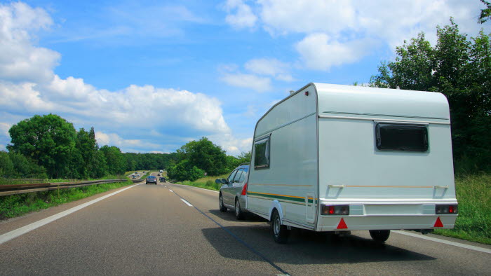 Bil med campingvogn på landevej