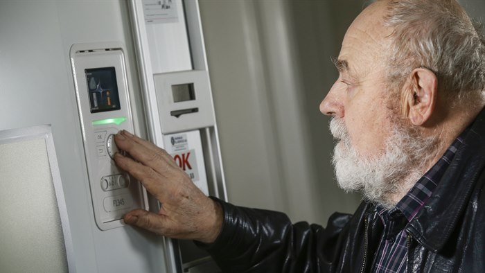 Mand tjekker elforbrug på kontrolpanelet til sin varmepumpe