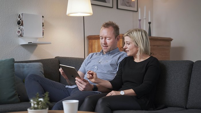 Par sidder i sofaen med tablet