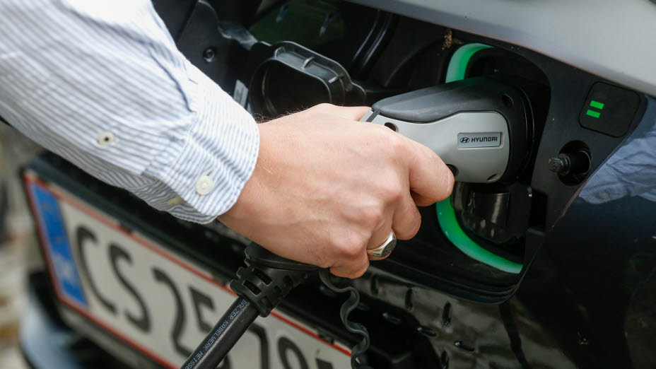 Hånd holder ladekabel til bil