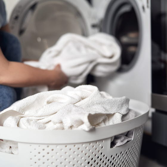 Kurv med håndklæder foran vaskemaskine