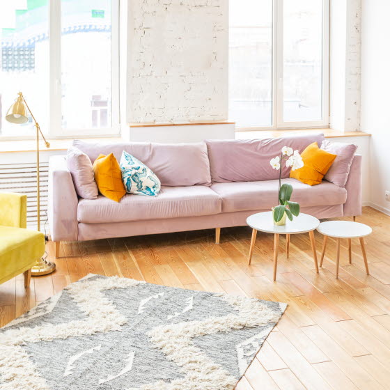 Rosa sofa og hvide sofaborde i lys stue
