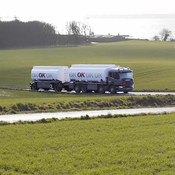 OK tankvogn med hænger på vej gennem landskab med grønne marker