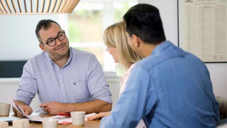 Mand og par drikker kaffe ved bord varmeumper rådgivning