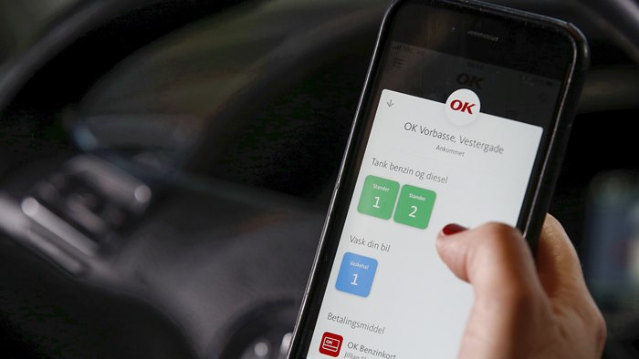 Mobiltelefon med OK's app med valg af tankstander på skærmen