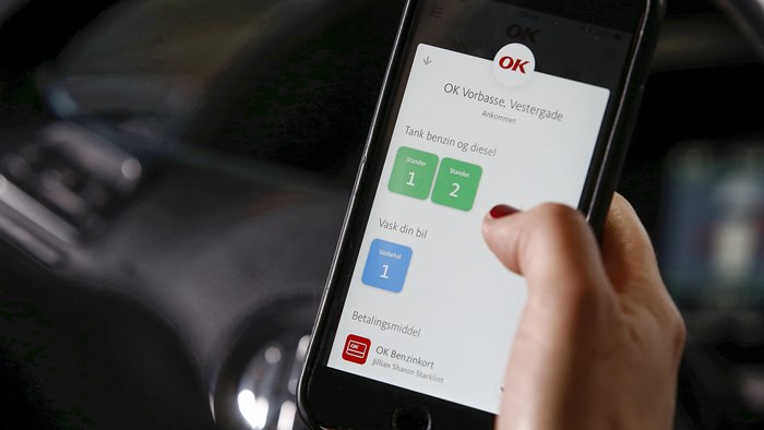 Mobiltelefon med OK's app med valg af tankstander på skærmen