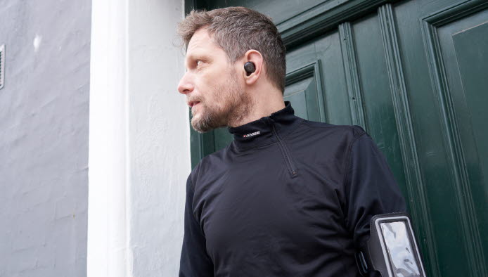 Mand iført løbetøj med mobiltelefon på armen