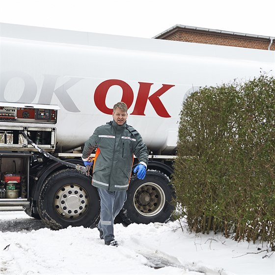 En af OK's tankvognschauffører på vej ind til hus med olieslange i hånden