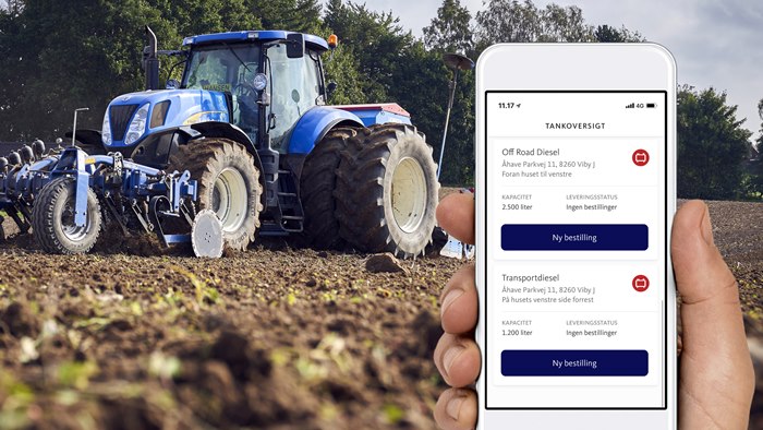 Visning af OK's bestil-app på mobiltelefon med traktor på mark i baggrunden