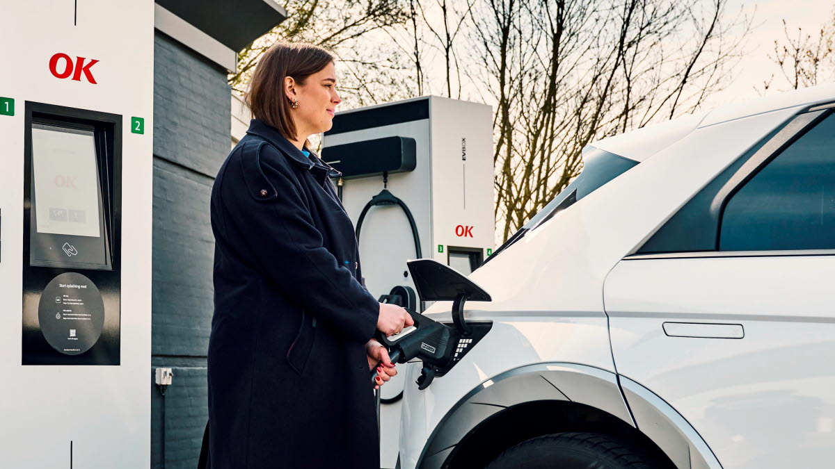 Kvinde ved ok ladestation lader elbil