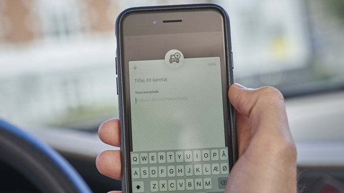 Mobiltelefon med visning af tilføj køretøj til OK's app 