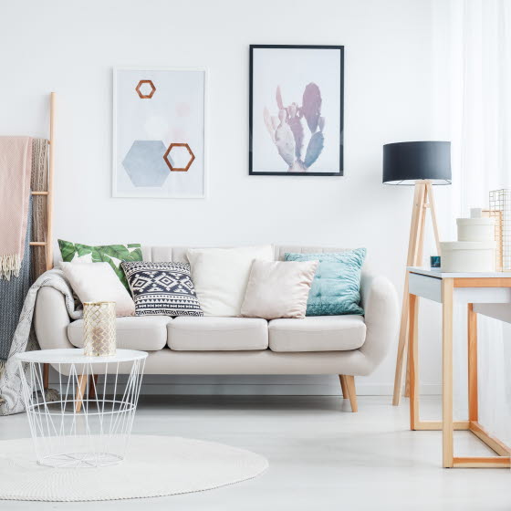 Lille hvid sofa fyldt med tæpper og puder