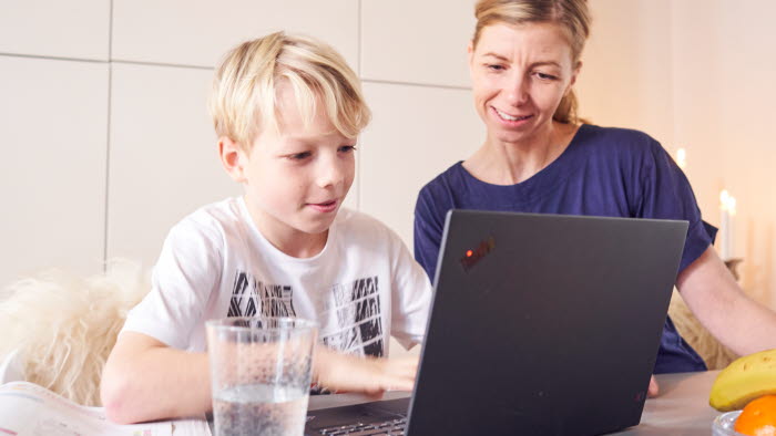 Dreng og mor sidder foran bærbar PC sammen