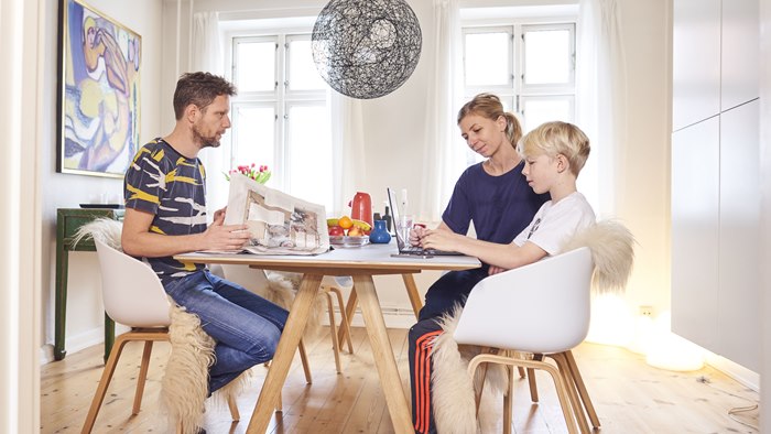 Far, mor og søn siddende ved spisebord
