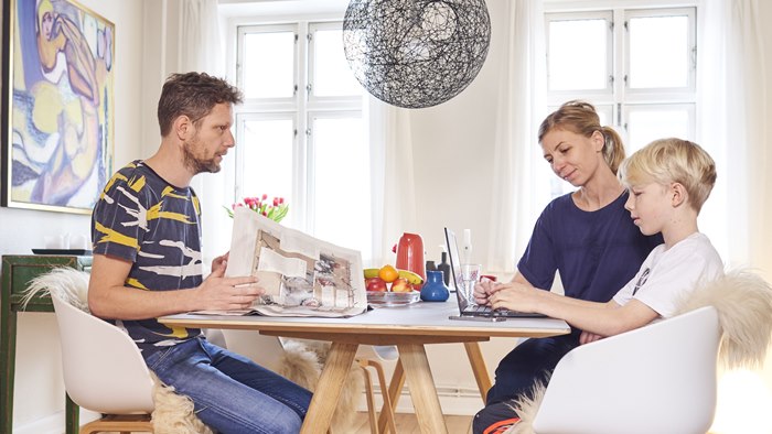 Far, mor og søn siddende ved spisebord