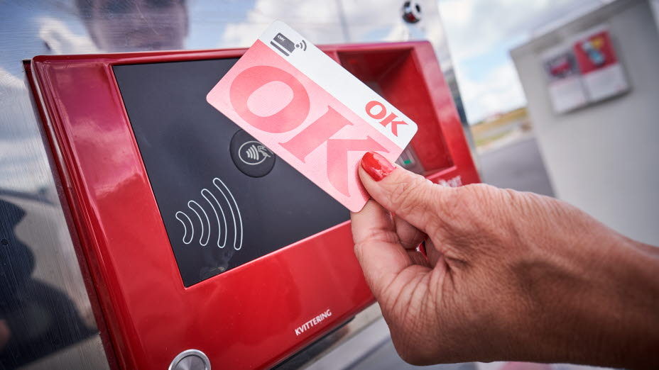 Kvindehånd der holder et OK Kort op til kontaktløs betaling