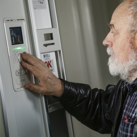 Mand tjekker elforbrug på kontrolpanelet til sin varmepumpe